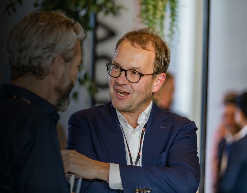 Two professionals talking during a business event, emphasizing communication and collaboration.